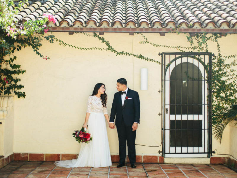 couple holding hands in front of house